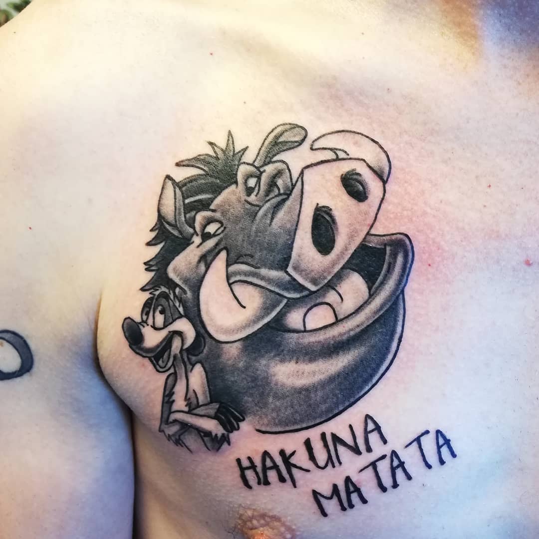 Tattoo of Timon and Pumbaa with "Hakuna Matata" text on a chest